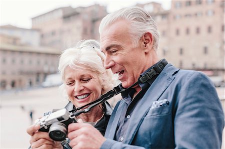 senior couple sight seeing - Tourist couple reviewing digital camera in town square, Siena, Tuscany, Italy Stock Photo - Premium Royalty-Free, Code: 649-08987804