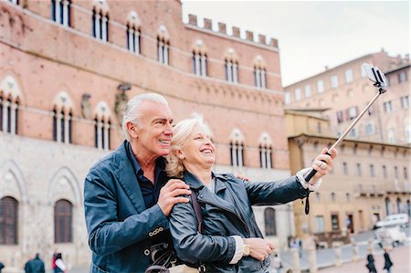 senior couple sight seeing - Tourist couple using selfie stick in city, Siena, Tuscany, Italy Stock Photo - Premium Royalty-Free, Code: 649-08987809