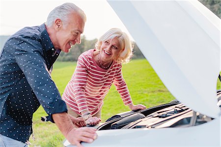 Easy going tourist couple looking at car engine on rural roadside, Siena, Tuscany, Italy Stock Photo - Premium Royalty-Free, Code: 649-08987849