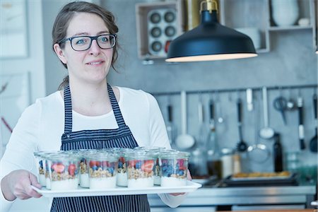 Female chef holding tray of berry desserts Stock Photo - Premium Royalty-Free, Code: 649-08987879