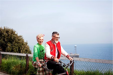 Quirky couple sightseeing on tandem bicycle, Bournemouth, England Stock Photo - Premium Royalty-Free, Code: 649-08987947
