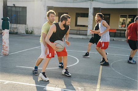 simsearch:649-09002714,k - Friends on basketball court playing basketball game Photographie de stock - Premium Libres de Droits, Code: 649-08988165