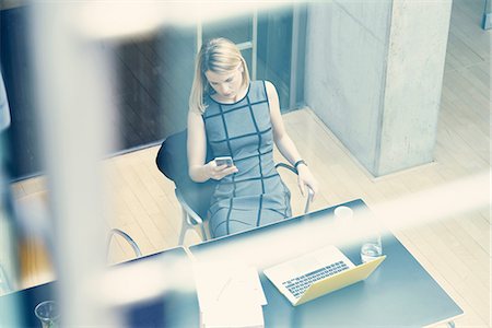 simsearch:649-08968796,k - High angle window view of young businesswoman looking at smartphone at office desk Foto de stock - Sin royalties Premium, Código: 649-08988205