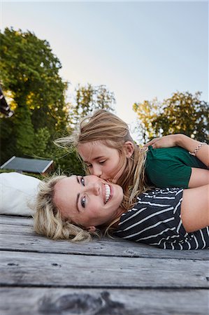 Mother and daughter lying on wooden decking outdoors Stock Photo - Premium Royalty-Free, Code: 649-08988413