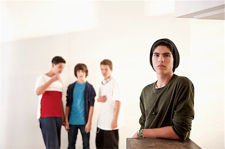 simsearch:649-06844687,k - Teenage boy leaning on box with friends in background Stock Photo - Premium Royalty-Free, Code: 649-09004340