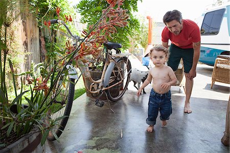 simsearch:649-07437981,k - Son running on patio with father watching Stock Photo - Premium Royalty-Free, Code: 649-09004451