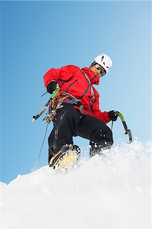 Mid adult man climbing on snow, low angle Stock Photo - Premium Royalty-Free, Code: 649-09004654