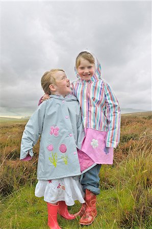 raincoat hugging - 2 little girls laughing in the moorlands Stock Photo - Premium Royalty-Free, Code: 649-09002495