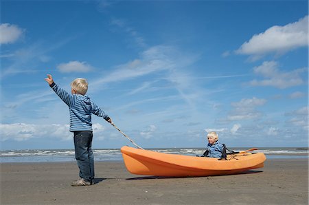 Brothers navigating a canoe on the beach Stock Photo - Premium Royalty-Free, Code: 649-09002540