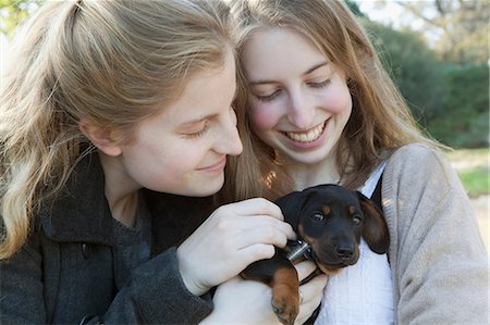simsearch:614-08876485,k - Teenage girls petting puppy outdoors Foto de stock - Sin royalties Premium, Código: 649-09002728
