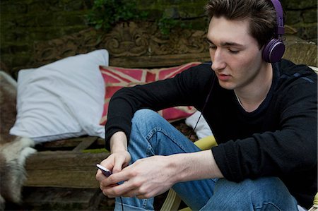 Teenage boy listening to mp3 player Stock Photo - Premium Royalty-Free, Code: 649-09002830