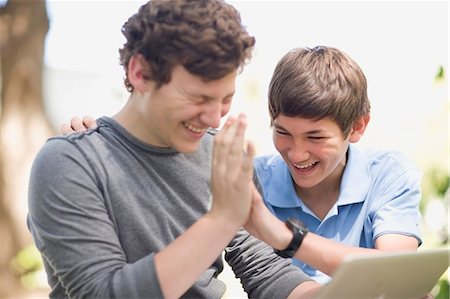 siblings and high five and two people - Teenage boys using laptop together Stock Photo - Premium Royalty-Free, Code: 649-09002878