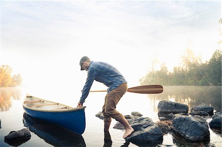 simsearch:614-06720064,k - Man pushing canoe into still lake Stock Photo - Premium Royalty-Free, Code: 649-09002956