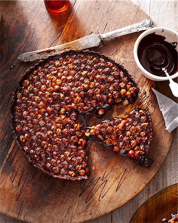 simsearch:649-09206597,k - Chocolate hazelnut tart on wooden board Photographie de stock - Premium Libres de Droits, Code: 649-09003096