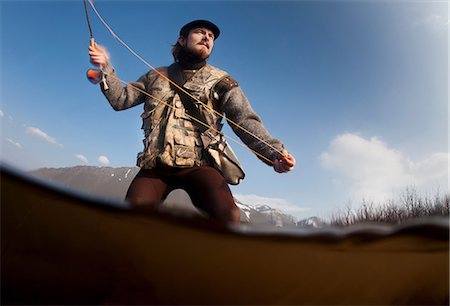 Low angle view of man fishing in lake Foto de stock - Sin royalties Premium, Código: 649-09003444