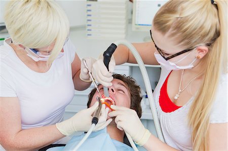 dental assistant (male) - Dentists working on patients teeth Foto de stock - Sin royalties Premium, Código: 649-09003463