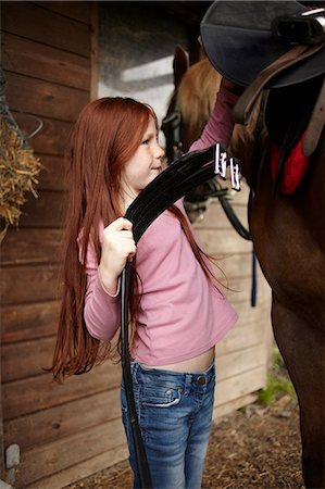 simsearch:649-09003830,k - Girl fastening horse's saddle at barn Stock Photo - Premium Royalty-Free, Code: 649-09003830