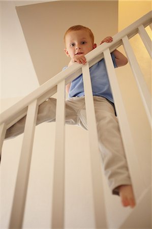 simsearch:649-08560718,k - Boy climbing banister of steps Photographie de stock - Premium Libres de Droits, Code: 649-09003842
