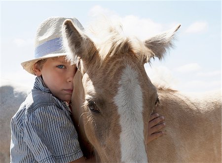 simsearch:649-09003874,k - Boy petting horse outdoors Foto de stock - Royalty Free Premium, Número: 649-09003860