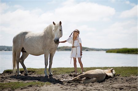 simsearch:649-09003874,k - Girl petting horses on sandy beach Foto de stock - Royalty Free Premium, Número: 649-09003871