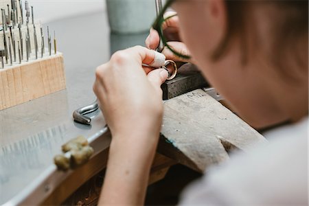Over shoulder view of female jeweller making ring at workbench Photographie de stock - Premium Libres de Droits, Code: 649-09016537