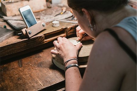 simsearch:649-08307026,k - Over shoulder view of female jeweller engraving metal at workbench Photographie de stock - Premium Libres de Droits, Code: 649-09016539