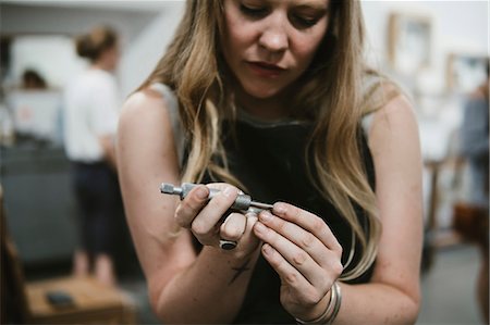 simsearch:649-09246440,k - Female jeweller using hand tool in jewellery workshop Foto de stock - Sin royalties Premium, Código: 649-09016589