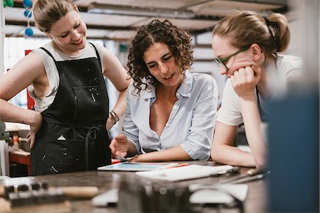 simsearch:649-08987855,k - Three female jewellers looking at digital tablet at workbench meeting Photographie de stock - Premium Libres de Droits, Code: 649-09016583