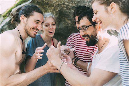 Five adult bouldering friends looking and laughing at smartphone, Lombardy, Italy Stock Photo - Premium Royalty-Free, Code: 649-09016740