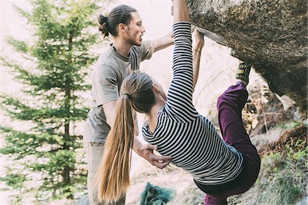 simsearch:614-09213863,k - Young male boulderer supporting woman climbing boulder, Lombardy, Italy Fotografie stock - Premium Royalty-Free, Codice: 649-09016771