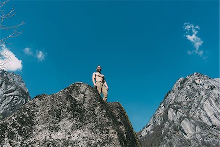 simsearch:649-08988159,k - Low angle view of bare chested young male boulderer looking down boulder top, Lombardy, Italy Photographie de stock - Premium Libres de Droits, Code: 649-09016793