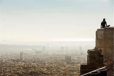 Backlit female tourist looking out from top of wall at Barcelona cityscape, Spain Foto de stock - Sin royalties Premium, Código: 649-09016937