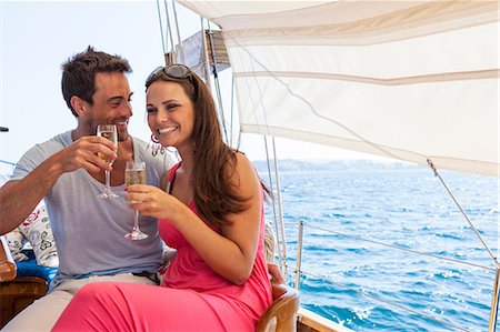 simsearch:649-08125036,k - Couple sitting on boat, on water, holding champagne flutes, smiling Photographie de stock - Premium Libres de Droits, Code: 649-09017124