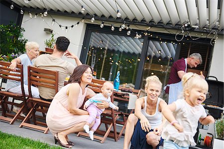 simsearch:649-08381693,k - Female toddler playing at three generation family lunch on patio Foto de stock - Royalty Free Premium, Número: 649-09025517