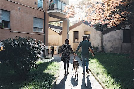 simsearch:649-08703319,k - Rear view of couple walking dog in city park Foto de stock - Royalty Free Premium, Número: 649-09025536