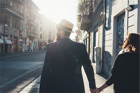 simsearch:649-08923913,k - Rear view of cool couple strolling on sunlit street Stock Photo - Premium Royalty-Free, Code: 649-09025548