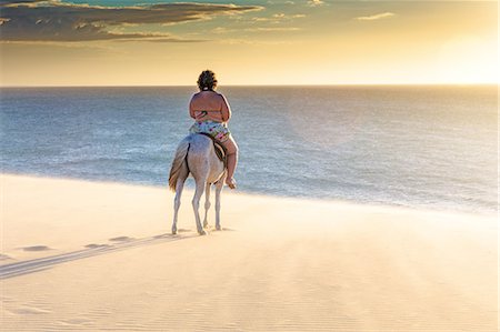 simsearch:649-09111386,k - Woman riding horse on beach, rear view, Jericoacoara, Ceara, Brazil, South America Stock Photo - Premium Royalty-Free, Code: 649-09025579