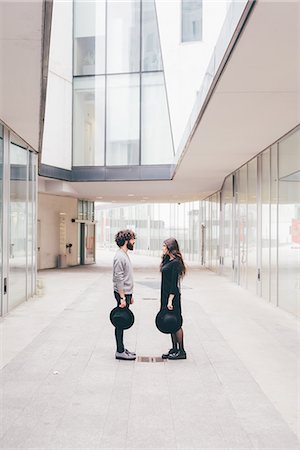 Young man and woman standing face to face in urban environment Stock Photo - Premium Royalty-Free, Code: 649-09025616
