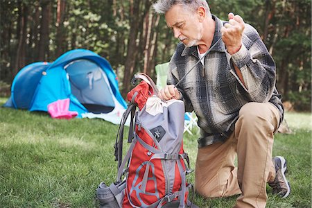 Senior man beside tent, packing rucksack Stock Photo - Premium Royalty-Free, Code: 649-09025683