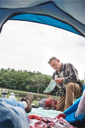 de 60 ans - Mature woman relaxing in tent, man outside tent, looking at map Photographie de stock - Premium Libres de Droits, Code: 649-09025693