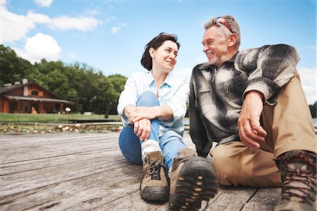 simsearch:649-08381569,k - Mature couple relaxing on wooden decking, smiling Stock Photo - Premium Royalty-Free, Code: 649-09025709