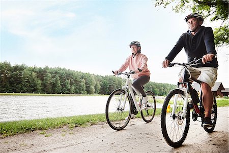 simsearch:632-05816481,k - Mature couple cycling beside lake Photographie de stock - Premium Libres de Droits, Code: 649-09025913