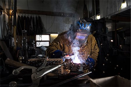 simsearch:649-09026034,k - Blacksmith in welding mask welding metal in workshop Photographie de stock - Premium Libres de Droits, Code: 649-09026030