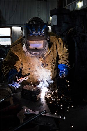 simsearch:649-09026034,k - Blacksmith in welding mask welding metal in workshop Photographie de stock - Premium Libres de Droits, Code: 649-09026033
