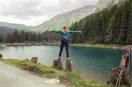 Rear view of woman balancing on rocks by lake, Tirol, Steiermark, Austria, Europe Stock Photo - Premium Royalty-Free, Code: 649-09026050