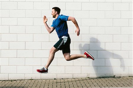 simsearch:614-07453280,k - Young male runner speed running along sidewalk Stock Photo - Premium Royalty-Free, Code: 649-09026109