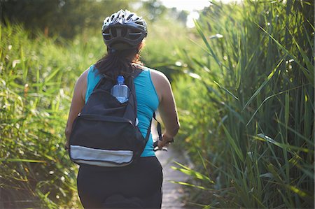 simsearch:649-09207891,k - Cyclist riding across field with tall grass Photographie de stock - Premium Libres de Droits, Code: 649-09026149