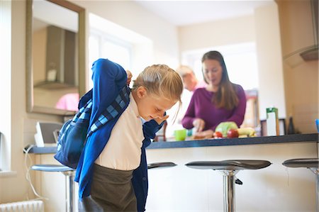 simsearch:649-09035507,k - Schoolgirl putting on school satchel in kitchen Stock Photo - Premium Royalty-Free, Code: 649-09035504