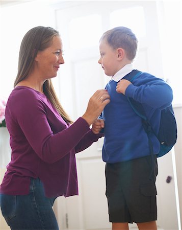 simsearch:614-08726632,k - Woman adjusting son's school sweater in hallway Fotografie stock - Premium Royalty-Free, Codice: 649-09035509