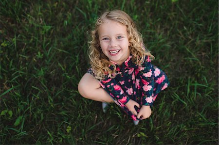 Overhead portrait of blond haired girl sitting on grass Fotografie stock - Premium Royalty-Free, Codice: 649-09035524